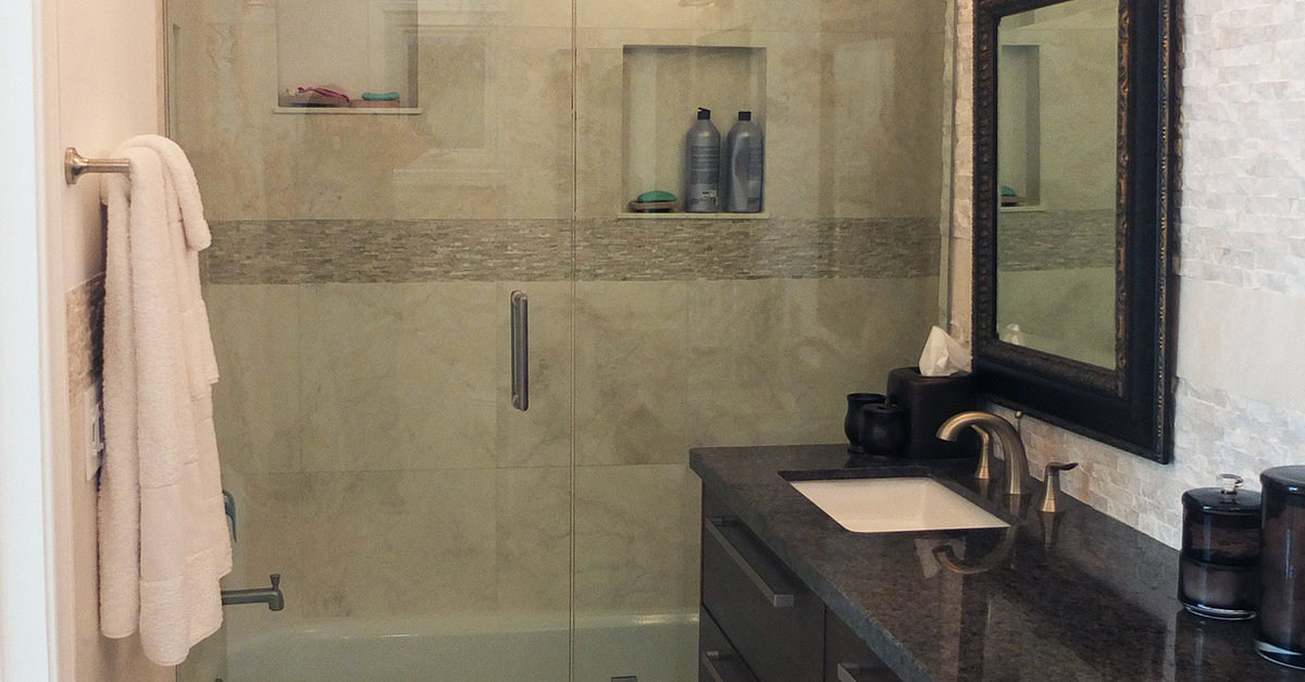 Malibu bathroom with a glass shower, stone tile, and dark wood vanity